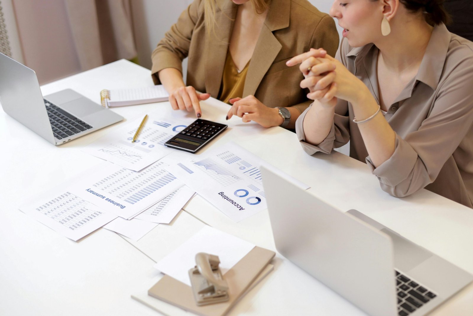 Two professionals collaborating on nonprofit accounting documents in a modern office setting.