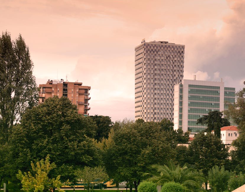 View of modern skyscrapers and lush greenery in Tirana, Albania during daylight.