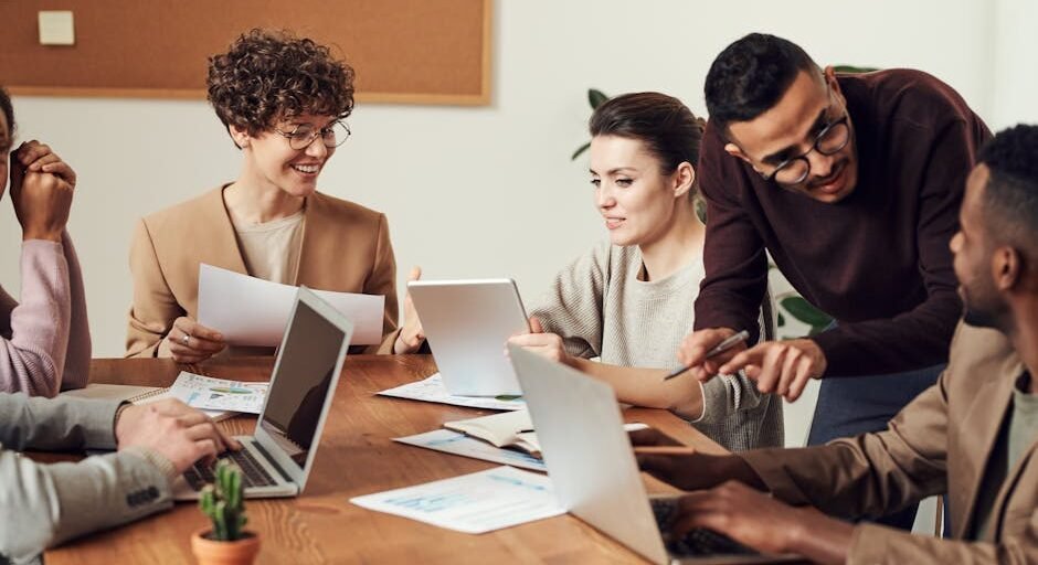 A diverse group of professionals engaged in a collaborative office meeting, sharing ideas and discussing projects.